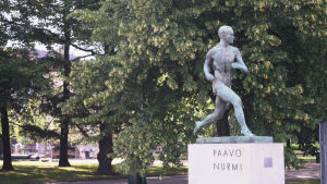 Löparen Paavo Nurmis staty representerar den finska löpningen. Statyns kurvor visar upp idealet av den finska löparen. Paavo Nurmis staty framför Olympiastadio i Helsingfors. I bakgrunden syns träd.