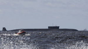Den atomdrivna ubåten K-535. Ubåten är av klass Borej som är Rysslands modernaste ubåtar utrustade med strategiska missiler. En ubåt ligger i vattnet. I förgrunden syns en motorbåt. Det är sjögång.