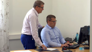 Berndt-Johan Lundström diskuterar med Christer Eklund. Bankdirektör Berndt-Johan Lundström och Christer Eklund vid en dator.