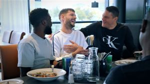 Interspelarna Hanson Boakai, Connor Ruane och Filip Valenčič vid lunchbordet. FC Inters fotbollsspelare äter lunch.
