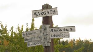 Vårdö - nära till allt. Skylt på Vårdö, på skylten står avstånd till olika orter, till exempel Helsingfors, Kumlinge och S:t Petersburg.