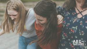Artikkelikuva Abitreenien artikkeliin. Kuvassa kolme nuorta naista nojaa toisiinsa ja nauraa.