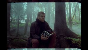 Kriitikko Kalle Kinnunen istuu sumuisessa metsässä muistikirja käsissään.