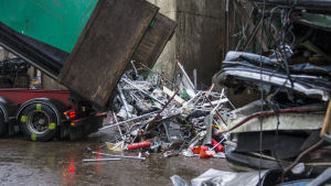 Kuorma-auto kippaa metalliromua maahan. 