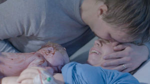 Matias suukottaa vaimoaan synnytyksen jälkeen.