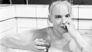 Näyttelijä Leea Klemola istuu kylpyammeessa lasi kädessä.