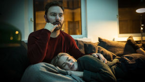Areenasta löytyy sisältö enemmän kuin ehdit katsoa! Mies ja nainen katsovat televisiota. Nainen makaa miehen sylissä, mies näyttää keskittyneeltä.