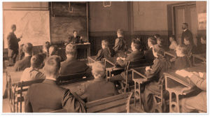 Tyttöjä ja poikia maantiedon tunnilla Brobergskan yhteiskoulussa1890-luvulla.