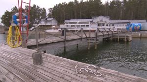 Gästhamnen Verkan kan erbjuda el, vatten och sälja ut bränsle och mat. Men dörren till dusch och bastu hålls stängda i nuläget - såsom i många andra gästhamnar. Verkans gästhamn i Korpo, en grå byggnad med bryggor i förgrunden.