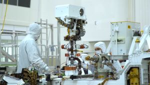 Tryckmätaren ligger inne i rovern men fuktmätaren syns på utsidan som en guldfärgad sticka på vänstra sidan av kamerahuvudets robotarm. Kamerahuvudet på Perseverance-rovern i Nasas renrum.