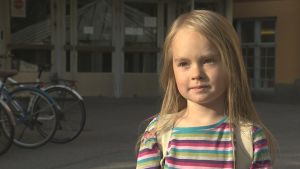 Elis Nylund tycker munskydd verkar obehagliga. En pojke med långt blont hår och randig skjorta.