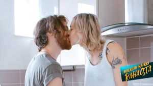 Mies ja nainen suutelevat keittiössä.