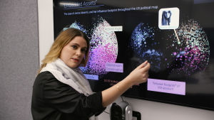 Camille François, forskare i cyberkonflikter, beskriver vilket inflytande den falska användarprofilen Jenna Abrams hade på sociala medier. En kvinna står framför en skärm som visar ett diagram över ett användarkonto på sociala medier.