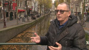 Bert Nap njuter av lugnet i den historiska stadskärnan. Invånaren Bert Nap står på en bro vid vid en av kanalerna i De Wallen. I bakgrunden ser man hur tomt det är på gatorna.