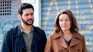 Paratiisi on myös kielikylpy. Sarjassa puhutaan suomea, espanjaa ja englantia. Andres (Fran Perea) & Hilkka (Riitta Havukainen) seisovat kadulla. Seinässä graffiteja.