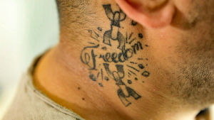 Kaulaan tatuoitu mustalla sana freedom.