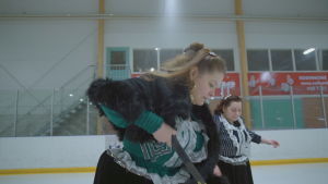 Det är inte fråga om att ingen skulle våga bryta den här traditionen. I dagens värld är det ingen som tvingar dig att bära kjol, säger Emma. Nainen kuljettaa kiekkoa jäähalissa.