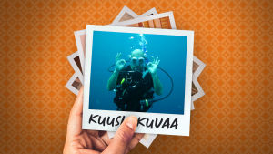 Mies sukellusvarusteissa veden alla näyttää kameralle molemmilla käsillään ok-merkkiä.