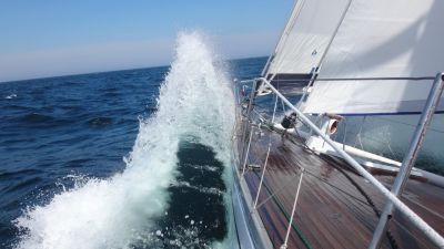 Vågorna slår i sidan på segelbåten.