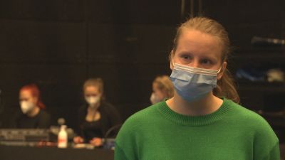 Charlotta Ingraeus i förgrunden med ansiktsskydd. I bakgrunden sitter ljudtekniker.