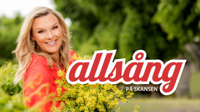 Programledaren Sanna Nielsen i röd skjorta gula blommor i famnen