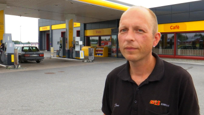 Man poserar vid bensinmack.