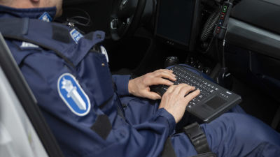 En polis skriver ut böter i en bil.