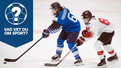 Jenni Hiirikoski med pucken och en schweizisk spelare bakom henne.