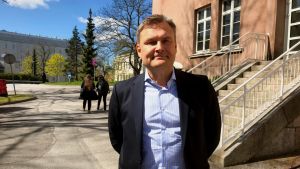 Matti Bergendahl är positivt överraskad över förtroendet. en man i kostym står och ler i soligt och grönskande vårväder på en parkeringsplats