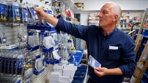 Stig Eggert ser inte många fördelar för småbutikerna när näthandeln växer. Stig Eggert placerar hänglås på vägghyllan i en butik.