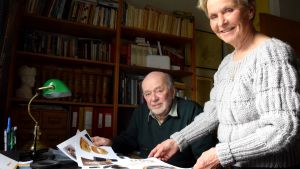 Bo Wessman och Satu Torstila har forskat i arkiven. en man och en kvinna tittar på gamla bilder