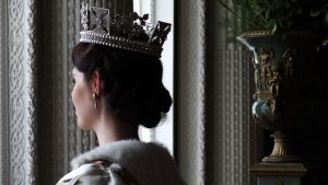 Nuori kuningatar Elisabeth seisoo ikkunan ääressä kruunu päässään ja viitta yllään.