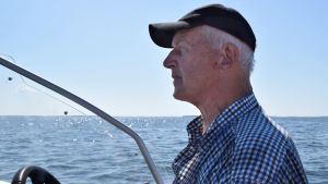 Börje Holmberg har fiskat hela sitt liv och lever med havet. Börje Holmberg sitter i sin båt och ser ut över ett somrigt hav.