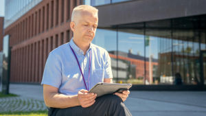 Kari Hiekkanen anser att den digitala användningens koldioxidutsläpp är ett stort problem särskilt därför att det inte talas om fenomenet. Kari Hiekkanen använder en surfplatta.