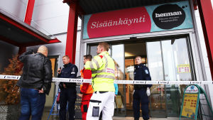 Yrkesinstitutet är tillfälligt placerat i köpcentret Herman. En av köpcentret Hermans ytterdörr. Utanför dörren syns räddningspersonal om en civilklädd person.