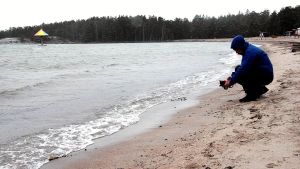 Både havet och Plagens badparasoll ser olika ut varje dag. man på strand med kamera