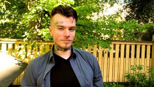 David Björkstörm från Hankmo. en ung man med tatueringar i ansiktet och på halsen i somrigt väder