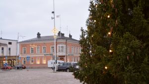 På Lovisa torg står en stor julgran klädd med julljus. Julgran och Lovisa torg.