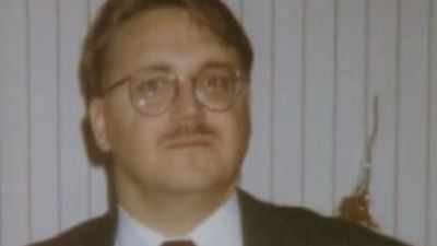 En man i mustasch och runda glasögon på en grynig gammal bild..