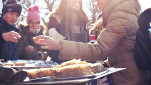 På Anders Abrahamssons gård fick eleverna provsmaka baguette bakat på urvete. Händer som sträcker sig mot en bricka med färsk baguette bakat på urvete.