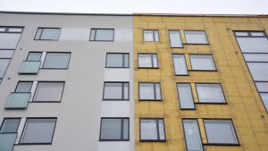 Att täcka in husfasaden under byggtiden, vilket man inte gjort på bilden, blir allt viktigare. En husfasad, hälften intäkt, hälften med isoleringen framme.