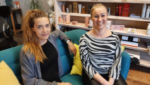 Lotte Stoor och Pernilla Backman i Karis ser ljust på framtiden, trots coronakrisen. Två damer i en soffa i en frisersalong