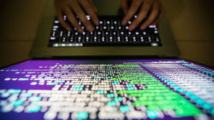 Konsten och kulturen har länge inspirerats av robotar och artificiell intelligens. På bilden syns en datorskärm med massa kodspråk. Bilden är tagen uppifrån och man ser hur två händer skriver på tangentbordet.