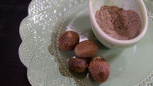 Muskottipähkinöitä ja jauhettua kardemummaa lautasella