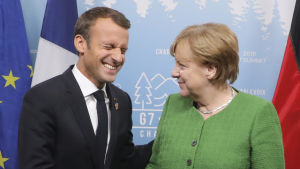 Emmanuel Macron och Angela Merkel ser ut att trivas tillsammans. Emmanuel Macron och Angela Merkel skakar hand udner G7-mötet i Kanada.