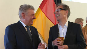 Kaj Arnö och Dieter Reiter i München. Kaj Arnö och överborgmästaren i München talar och skrattar tillsammans. Arnö håller en öl.