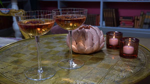 Cocktail White Summer Night sisältää vodkaa, seljankukkamehua, kotitekoista jääteetä ja karpaloita. Kaksi drinkkilasia pöydällä, jossa tecocktailit.