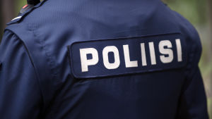 Var beredd på att berätta för polisen varför du ska lämna Nyland. Ryggtavlan av en polis.