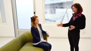 Eriksson testar ena soffan och berättar om tyget som är både bekvämt att vidröra och sköta om. Färgerna är också sådana att de inte ska väcka aggressioner eller starka känslor. Två kvinnor i ett nybyggt hus
