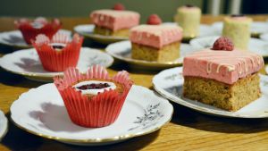 Barnens muffins har ett hjärta av hemlagad äppelmos på insidan. Runebergstårtor på ett bord.